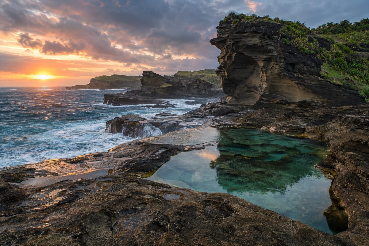 Illustration of dark sandstone rock formations and tidal pools beside foaming Pacific water in Biri, Northern Samar