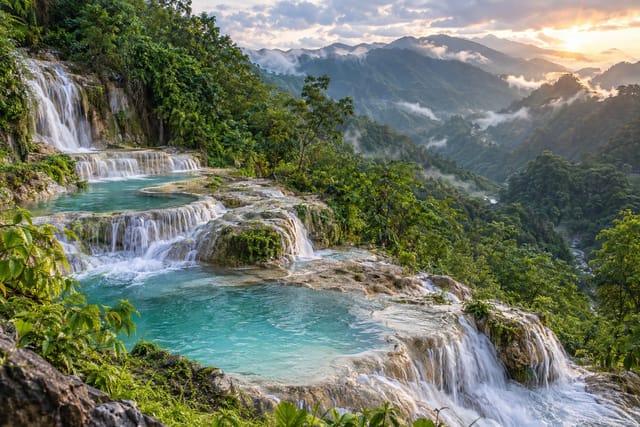 Illustration of terraced turquoise limestone cascades in a forested mountain valley in Abra